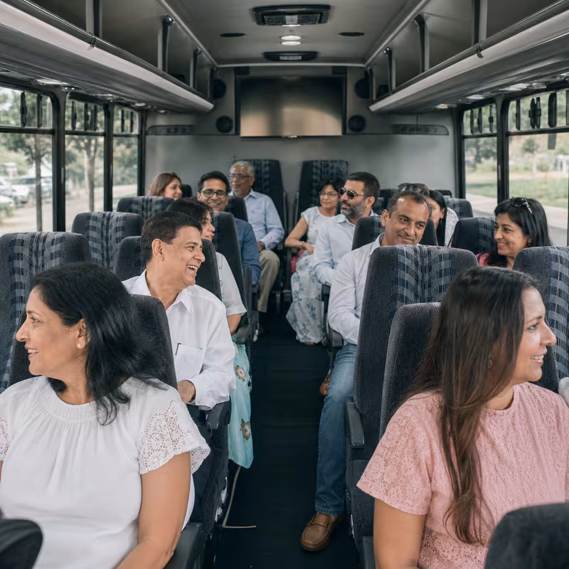 Group boarding a white charter bus for Private Event Transportation transportation in Orange