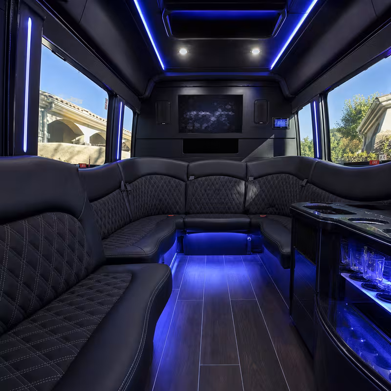 Party bus interior with wraparound leather seating and LED lighting in Orange