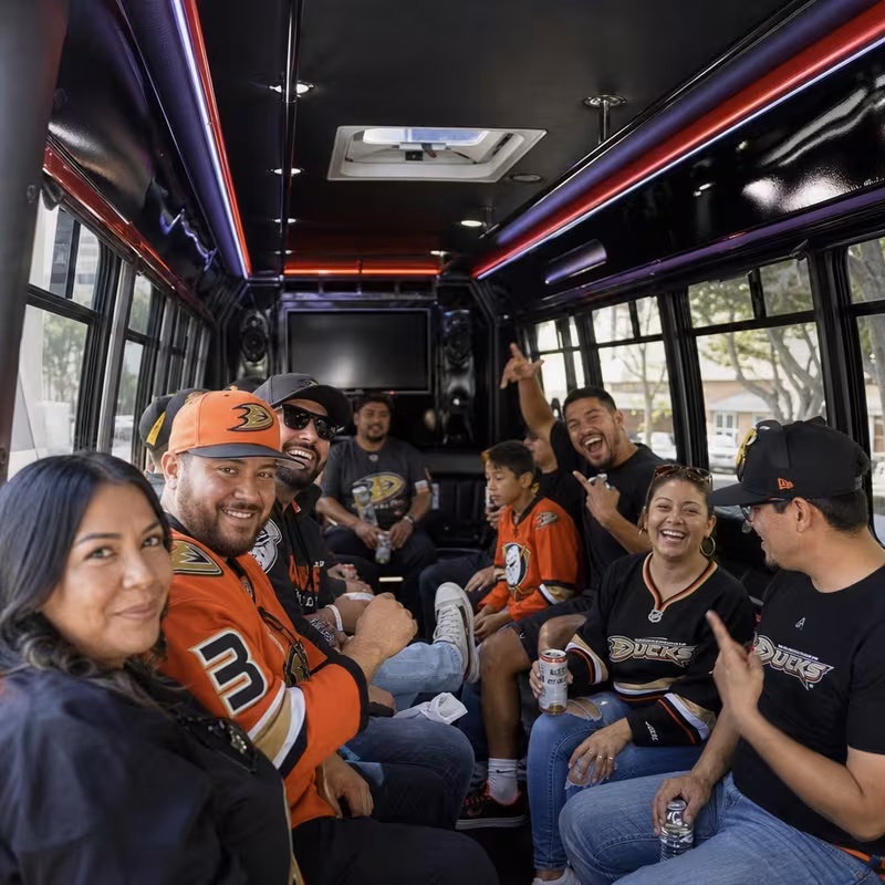 Group boarding a white charter bus for Sporting Event Transportation transportation in Orange